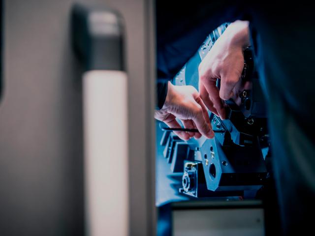 bild på två händer som reparerar fräsmaskin