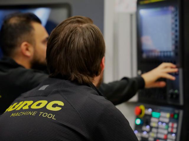 bild på två maskinoperatörer vid cnc-maskin