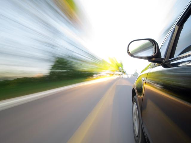 gul bil som körs längs med väg